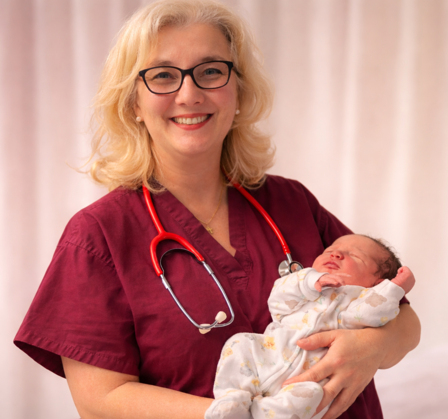 JD, an experienced midwife holding a newborn baby